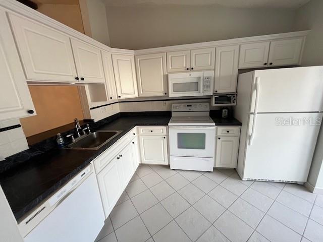 1725 Pine Ridge Way East, Unit C Palm Harbor, FL 34684 - Photo 7 of 28 a kitchen with a sink and white cabinets