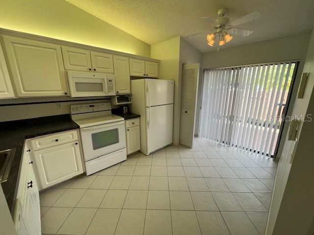 1725 Pine Ridge Way East, Unit C Palm Harbor, FL 34684 - Photo 8 of 28 a kitchen with white cabinets and white appliances