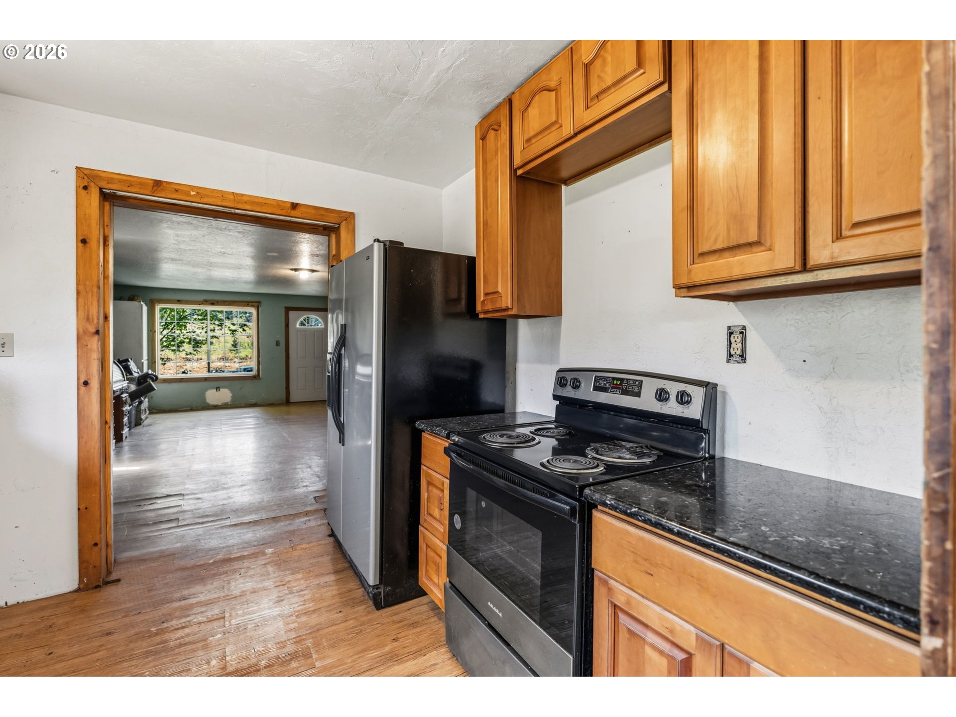 21542 Highway 126 Noti, OR 97461 - Photo 11 of 22 a kitchen with stainless steel appliances granite countertop a refrigerator a stove and a sink with wooden floor