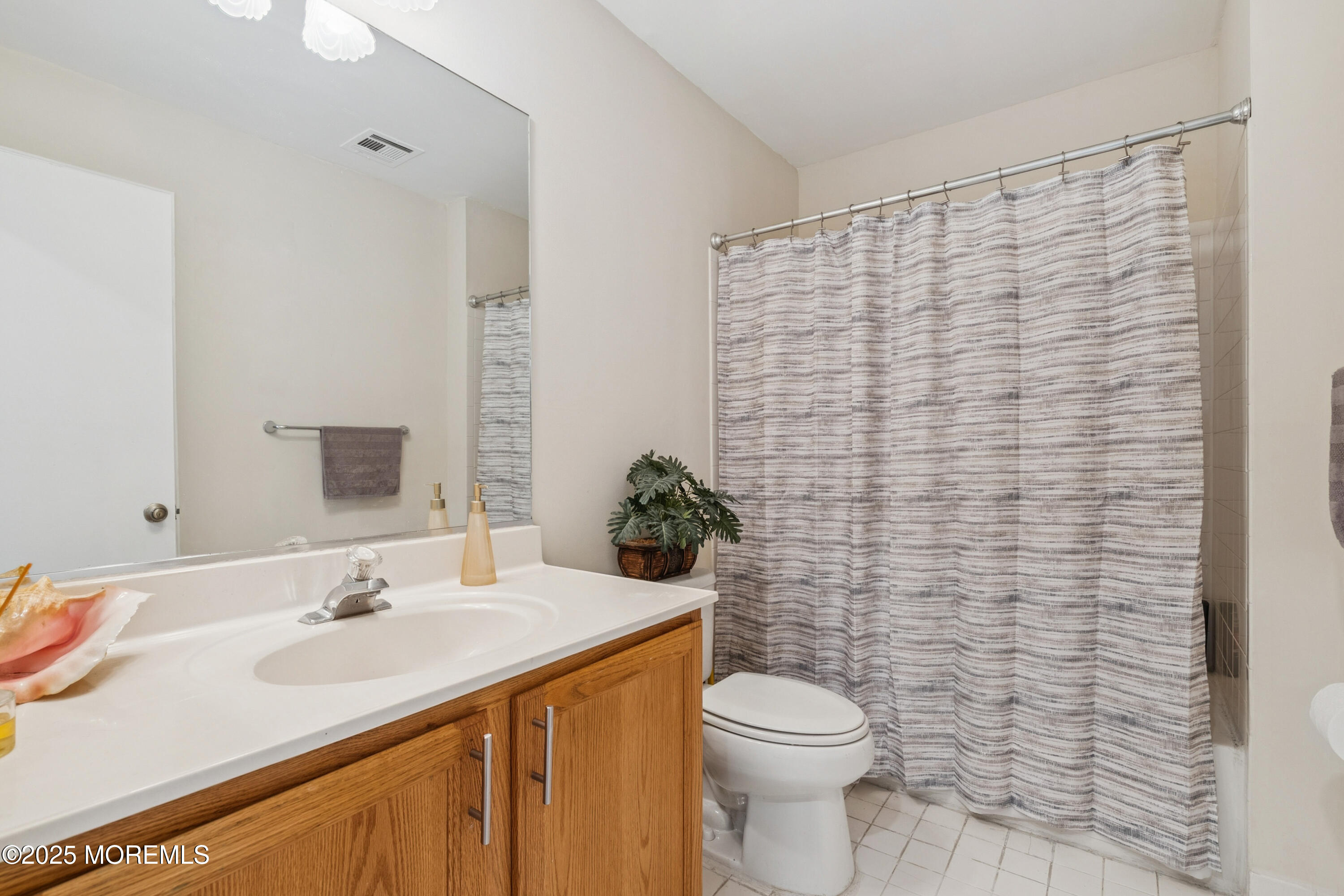 7 Devonshire Drive Hazlet, NJ 07730 - Photo 17 of 19 a bathroom with a sink a toilet and shower curtain