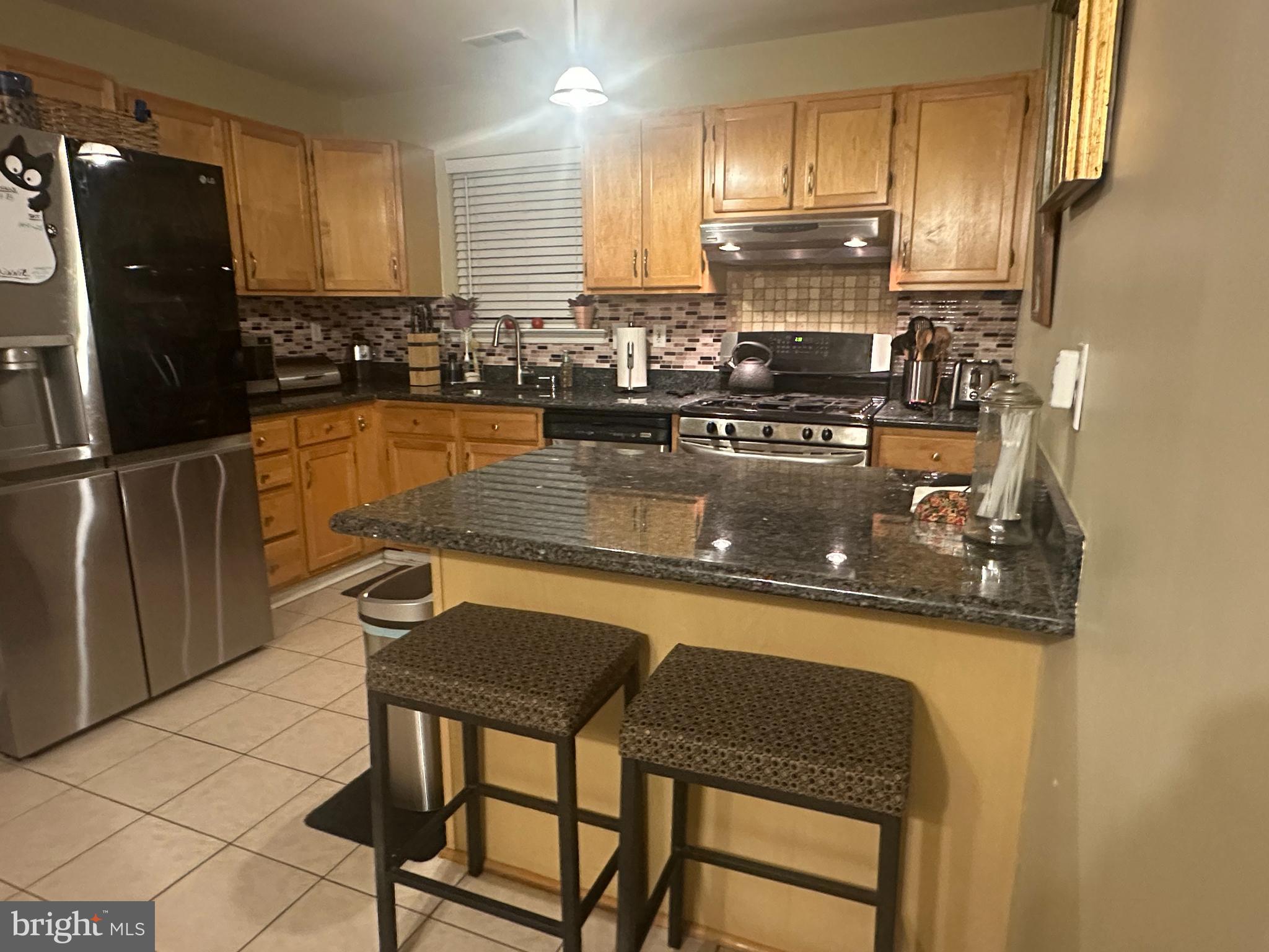 50 Haverford Road Runnemede, NJ 08078 - Photo 16 of 34 a kitchen with granite countertop a refrigerator a stove a sink and white cabinets with wooden floor