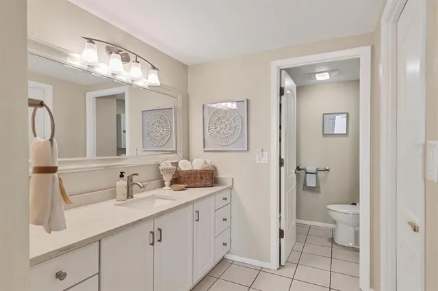 a bathroom with a double vanity sink mirror and toilet