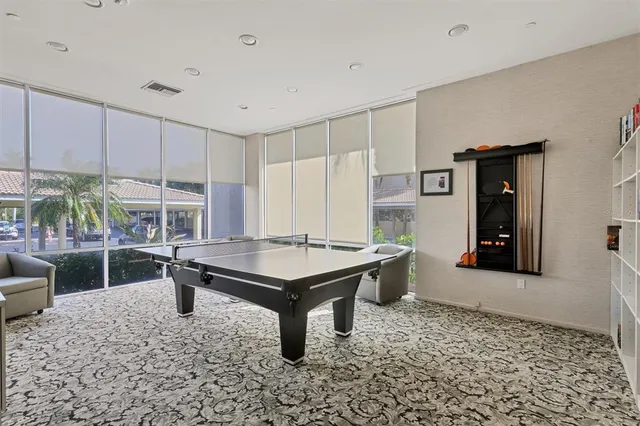 a room with pool table and windows