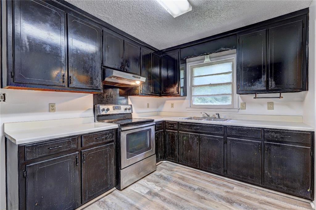 3266 Betty Place Macon, GA 31217 - Photo 3 of 10 a kitchen with granite countertop stainless steel appliances wooden cabinets and a sink