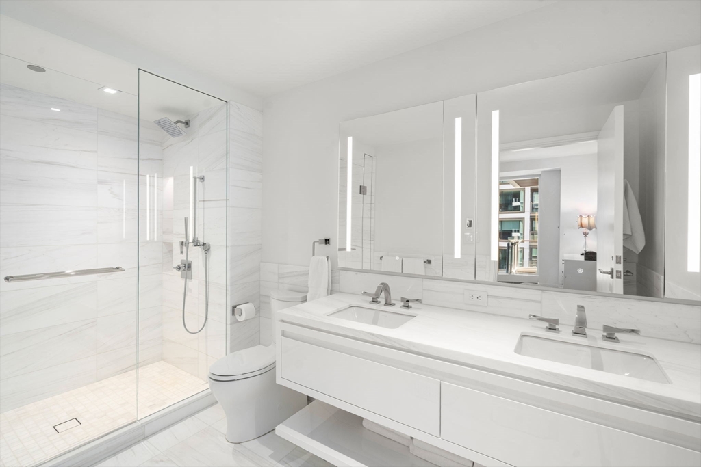 150 Seaport Boulevard, Unit 8A Boston, MA 02210 - Photo 14 of 27 a bathroom with a double vanity sink mirror double shower and a bathtub