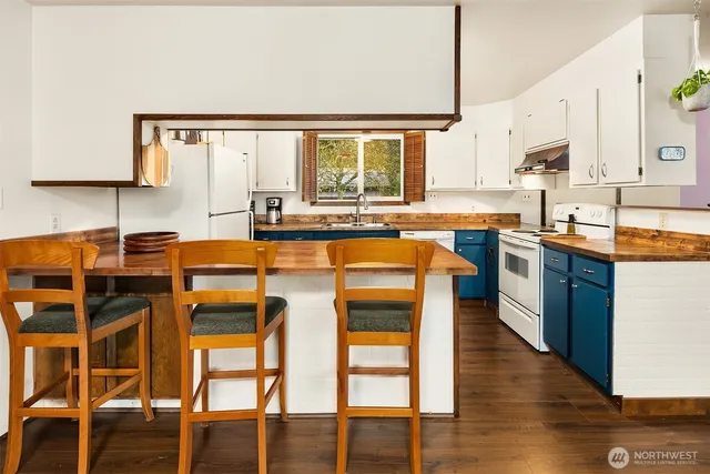a kitchen with appliances cabinets and chair