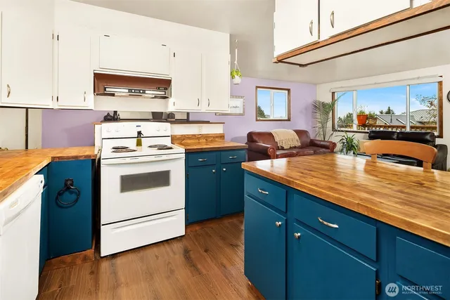 a kitchen with stainless steel appliances granite countertop a sink a stove and cabinets