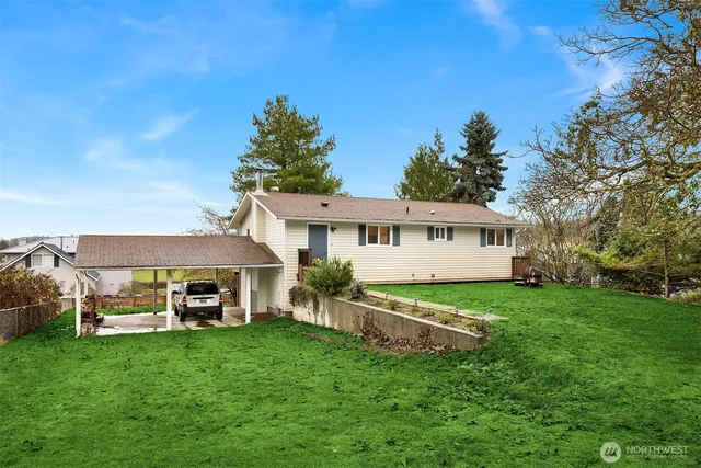 a view of a house with backyard and a tree