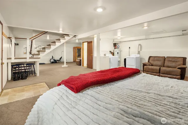 a spacious bedroom with a bed a couch and a potted plant on the dresser