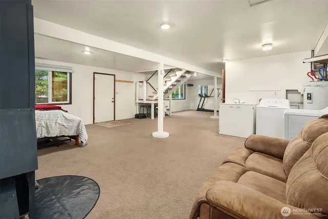 a living room with furniture and a gym machine with wooden floor