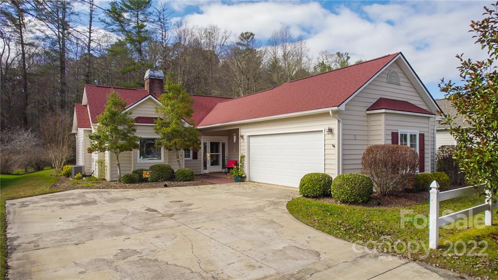 a view of a house with a yard and large tree