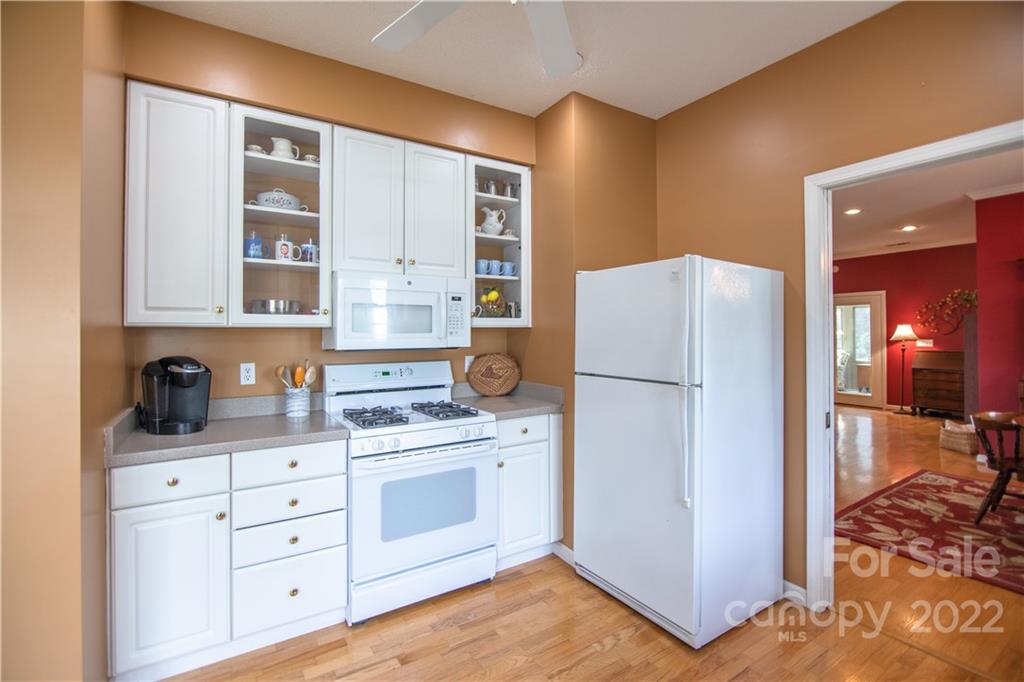 7 Sheffield Place Brevard, NC 28712 - Photo 4 of 30 a kitchen with white cabinets and white appliances