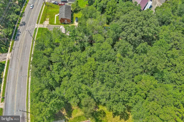 an aerial view of residential house with outdoor space and trees all around