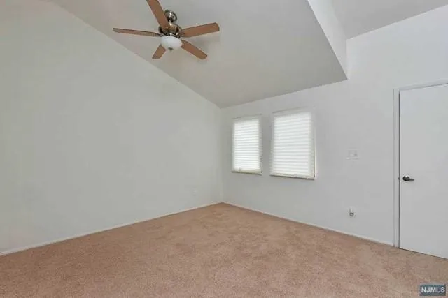 an empty room with a window and a fan