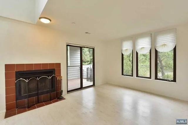 a view of a livingroom with a fireplace and window