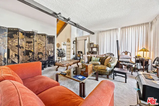 a living room with furniture a large window and a flat screen tv