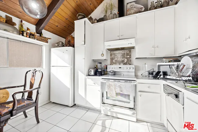 a kitchen with cabinets and chairs