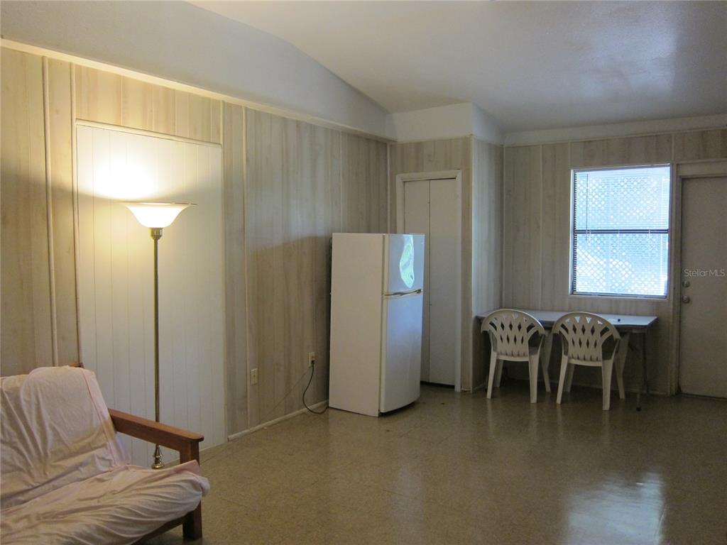 1602 Southwest Williston Road, Unit A Gainesville, FL 32608 - Photo 5 of 8 a living room with furniture a dining table and a refrigerator