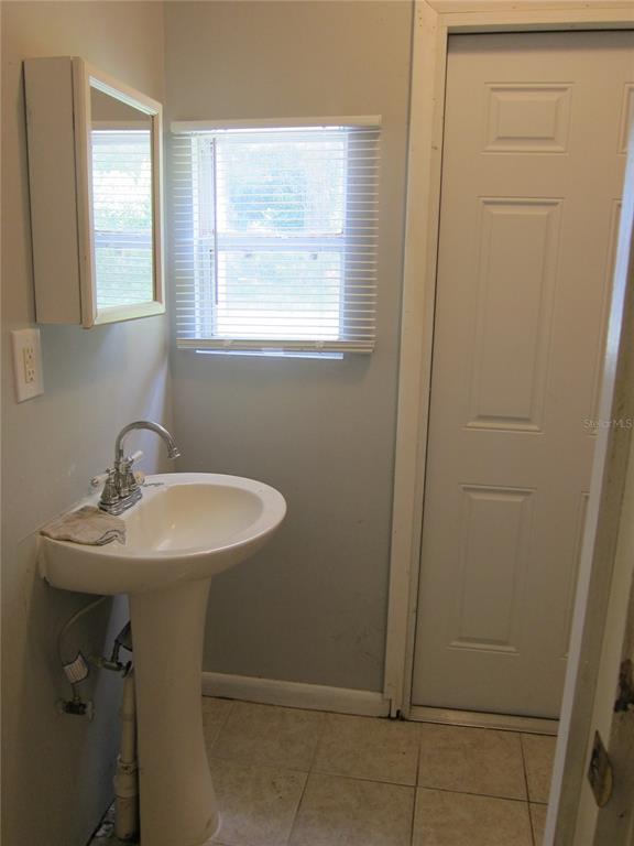 1602 Southwest Williston Road, Unit A Gainesville, FL 32608 - Photo 6 of 8 a bathroom with a sink a mirror and a window