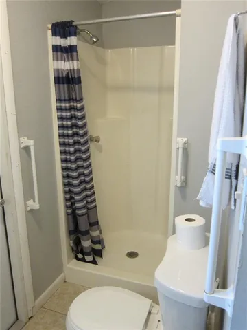 a bathroom with a shower a toilet and a sink