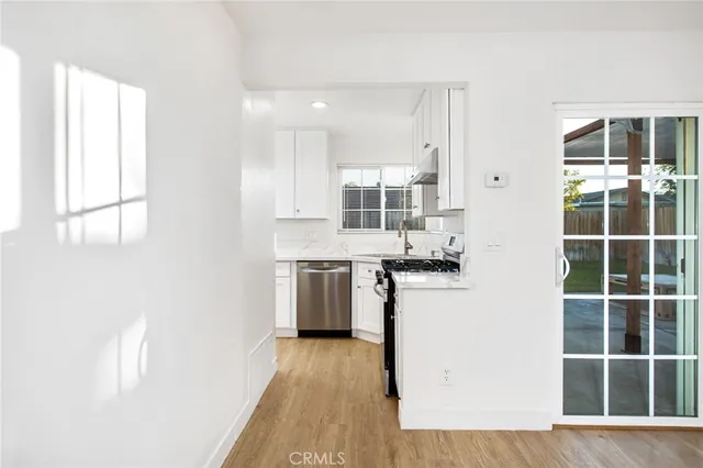 a kitchen with a refrigerator and wooden floor