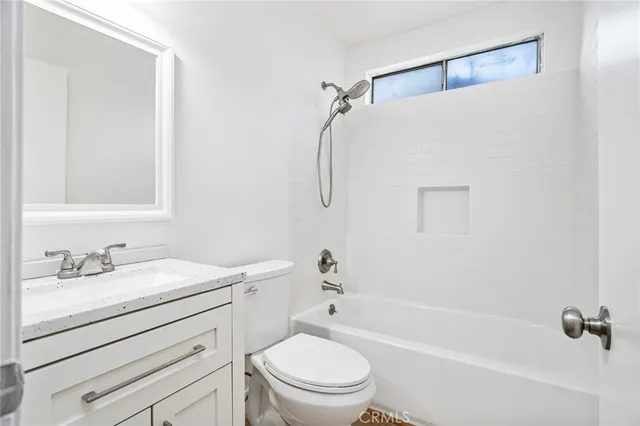 a bathroom with a sink toilet vanity and shower
