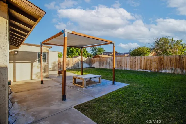 a view of a house with backyard and sitting area