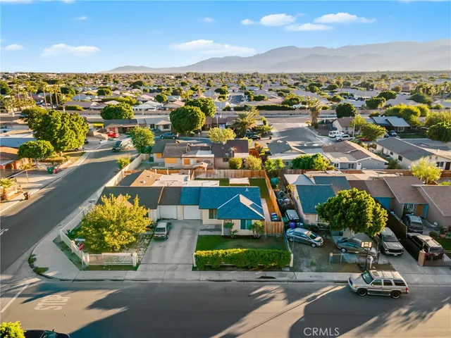 an aerial view of a city with lots of residential buildings ocean and mountain view in back