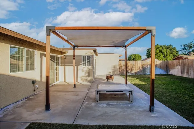 a patio with table and chairs and potted plants