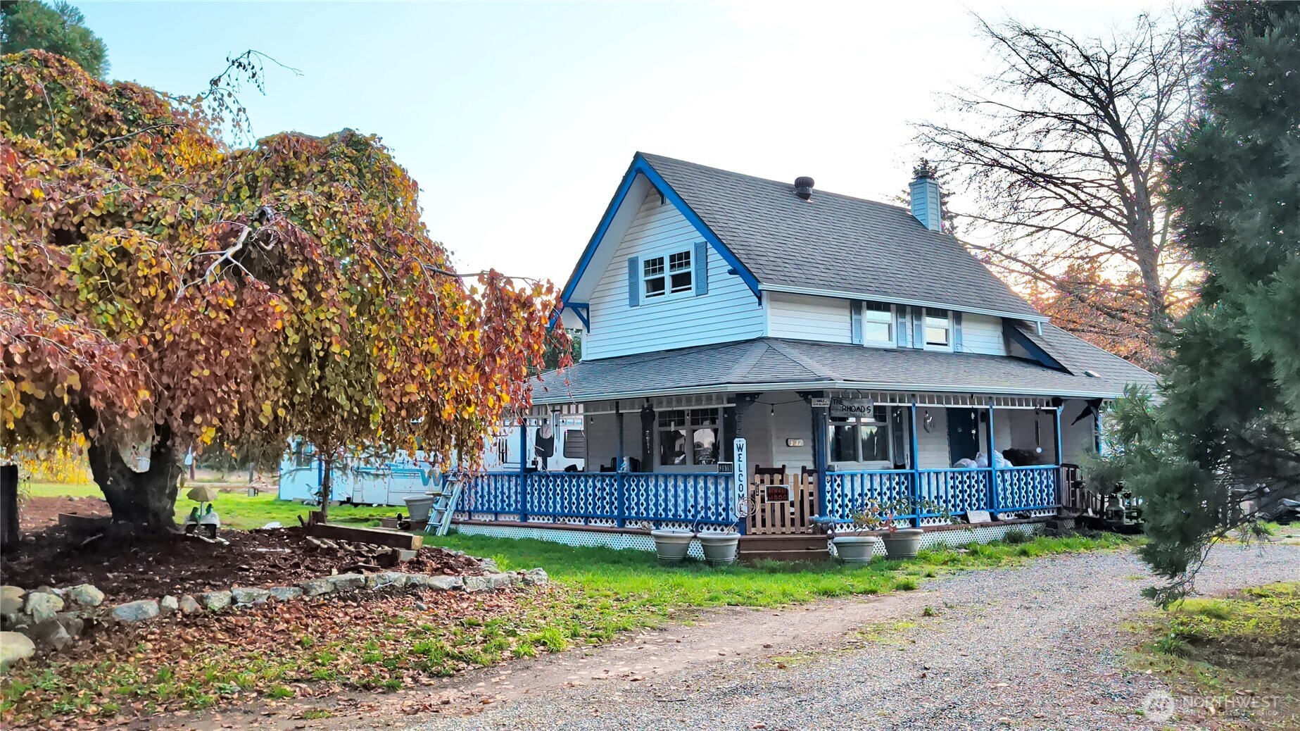 a view of a house with a yard and large tree