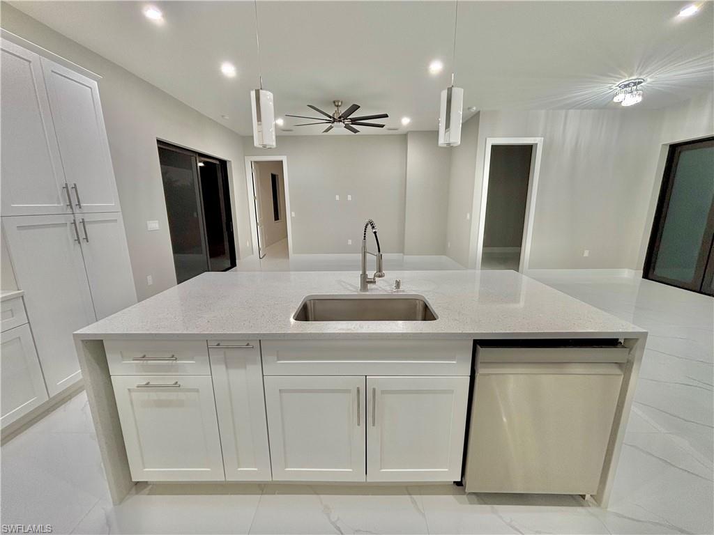 3904 12th Street Southwest Lehigh Acres, FL 33976 - Photo 7 of 12 a kitchen with a sink and a refrigerator