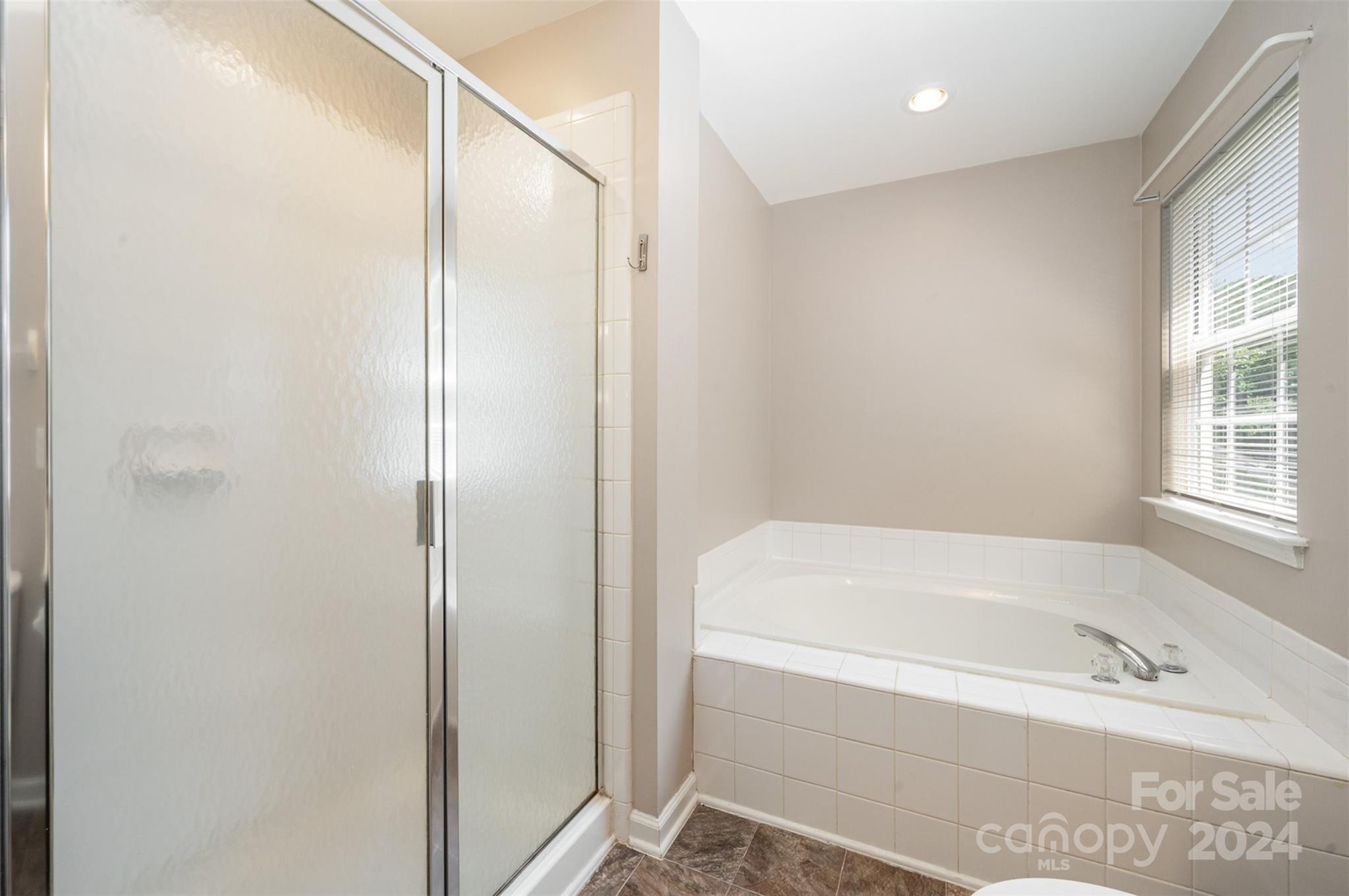 12032 Regent Ridge Lane Charlotte, NC 28278 - Photo 15 of 25 a bathroom with a bathtub and a shower