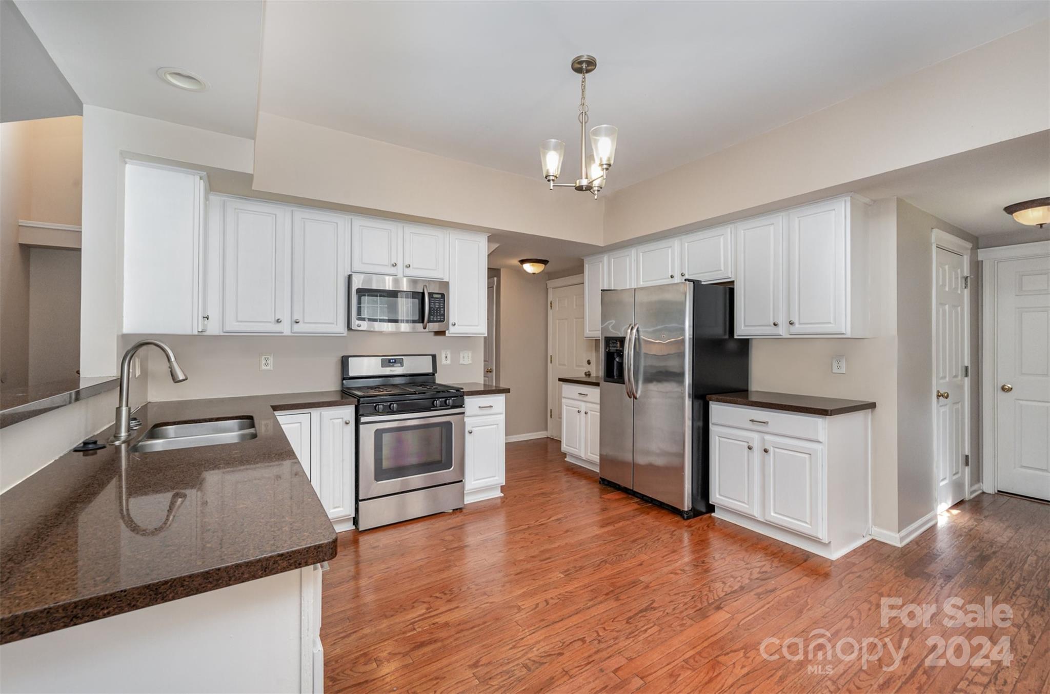 12032 Regent Ridge Lane Charlotte, NC 28278 - Photo 7 of 25 a kitchen with stainless steel appliances granite countertop a sink stove and refrigerator