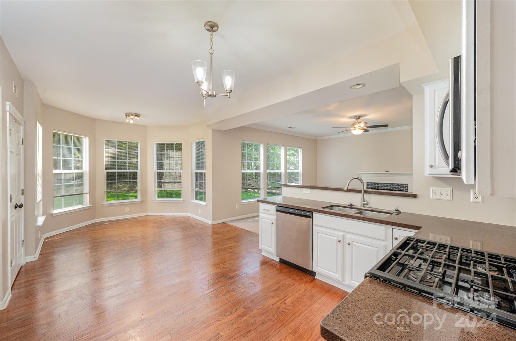 12032 Regent Ridge Lane Charlotte, NC 28278 - Photo 8 of 25 a large kitchen with stainless steel appliances granite countertop a sink stove and wooden floors
