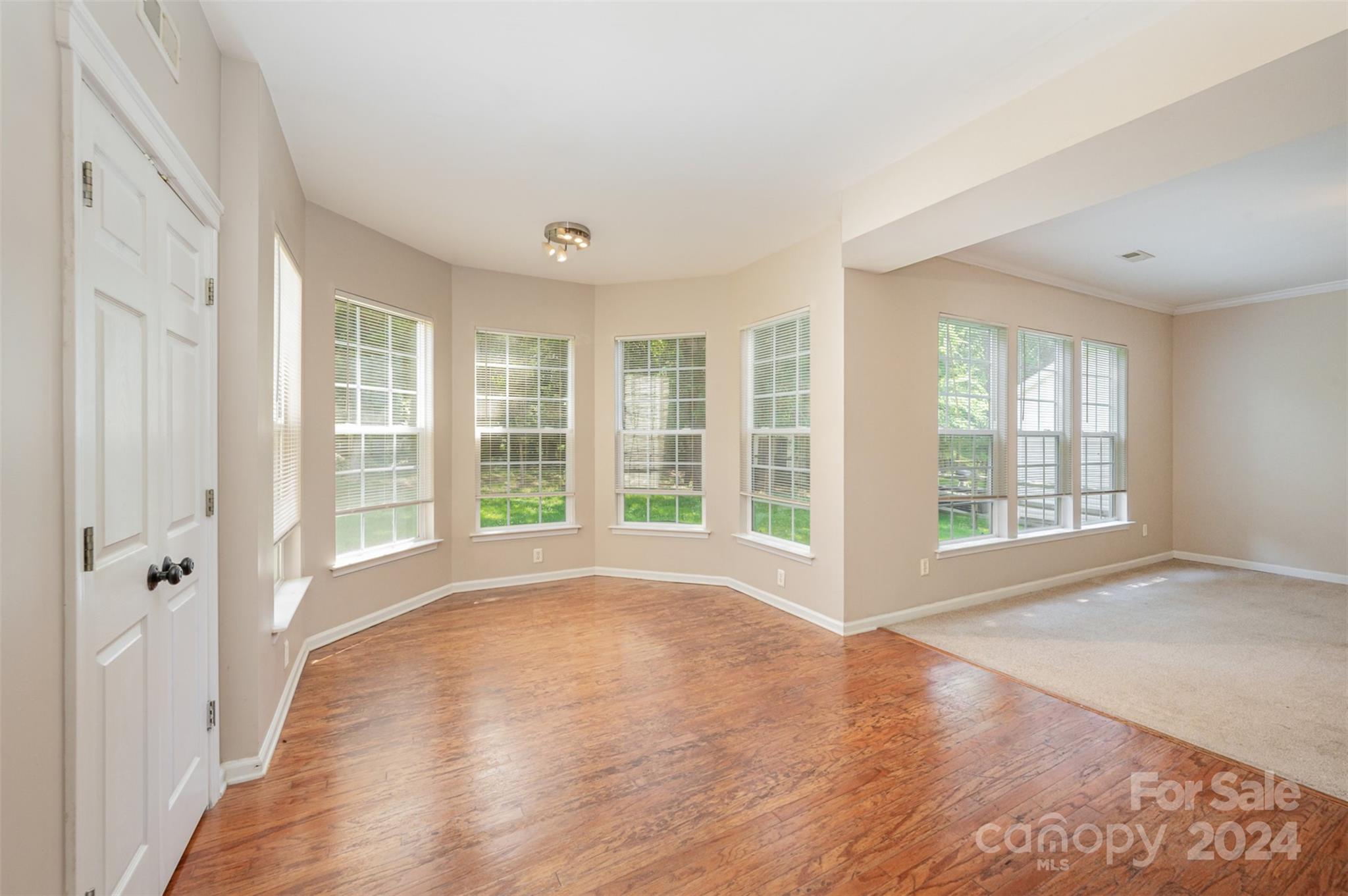 12032 Regent Ridge Lane Charlotte, NC 28278 - Photo 9 of 25 a view of an empty room with a window and wooden floor