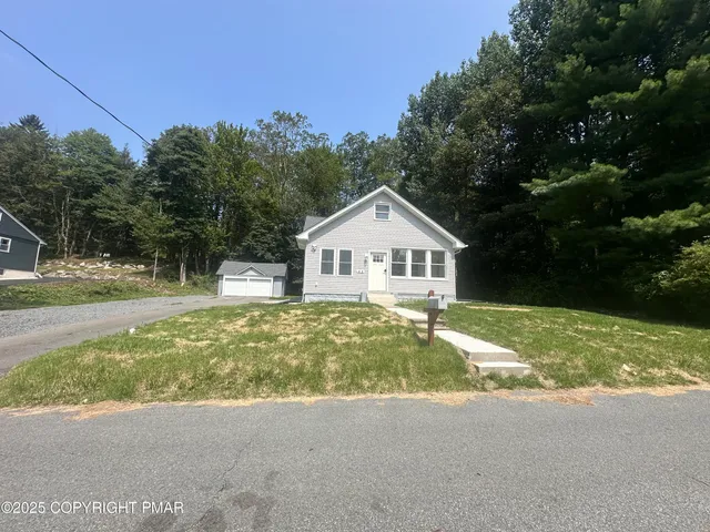 a view of a house with backyard and trees