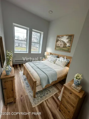 a bedroom with a bed and dresser with mirror