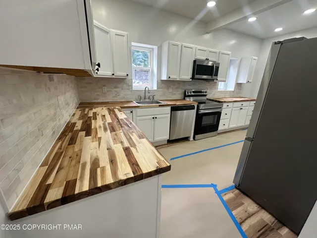 a kitchen with granite countertop a refrigerator stove and sink