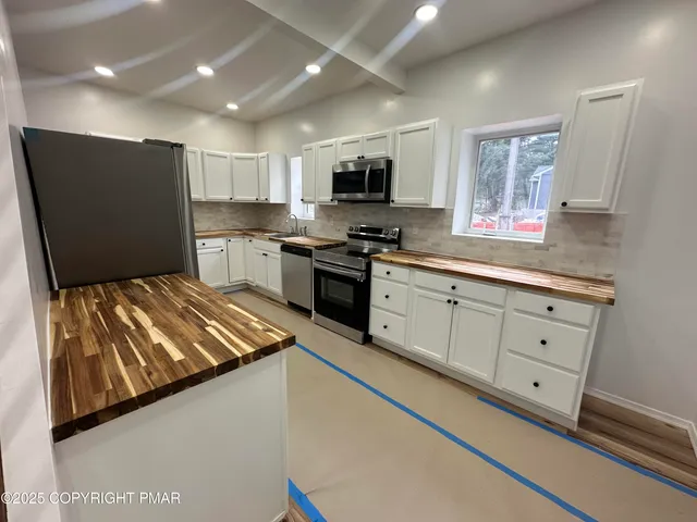 a kitchen with white cabinets and black appliances