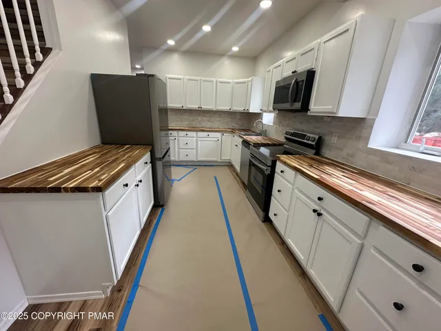 a kitchen with stainless steel appliances a refrigerator and a stove top oven