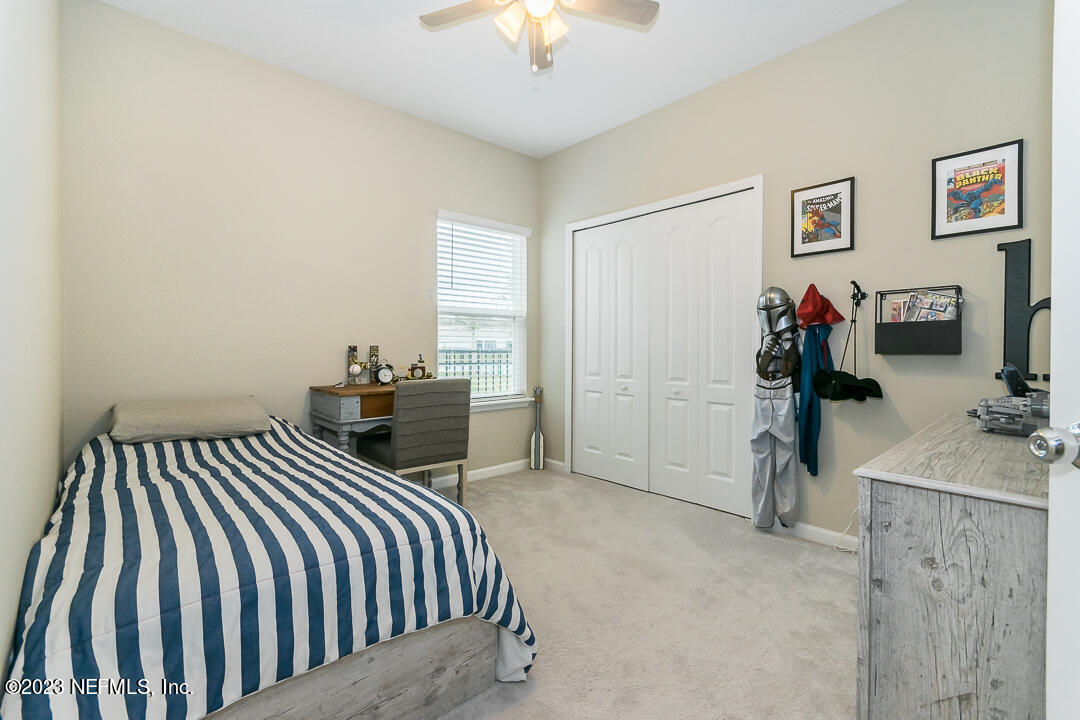 75751 Spoonbill Lane Yulee, FL 32097 - Photo 13 of 19 a bedroom with bed and a chandelier