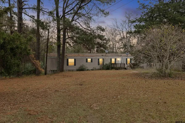a front view of a house with a tree