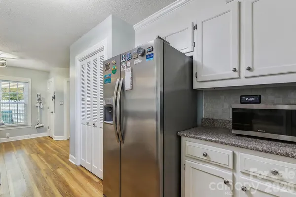 a kitchen with stainless steel appliances granite countertop a refrigerator a microwave and cabinets