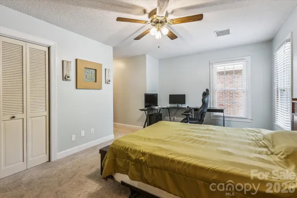 a bed sitting in a spacious bedroom next to a window