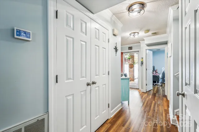 a view of a hallway with a white walls and wooden floor