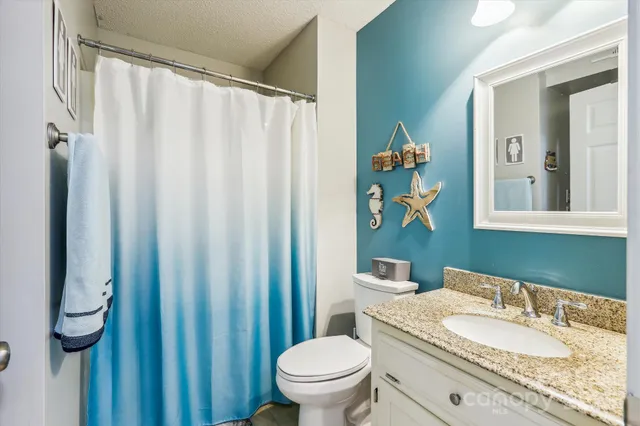a bathroom with a granite countertop sink and a mirror with toilet