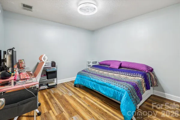 a bedroom with a bed and a wooden floor