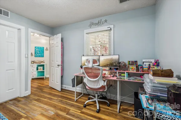 a work room with furniture and a wooden floor