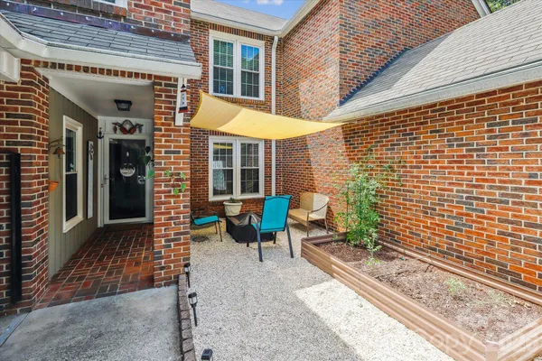 a view of a patio with table and chairs and wooden fence