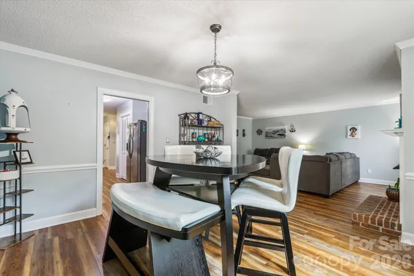 a view of a dining room with furniture a chandelier and wooden floor